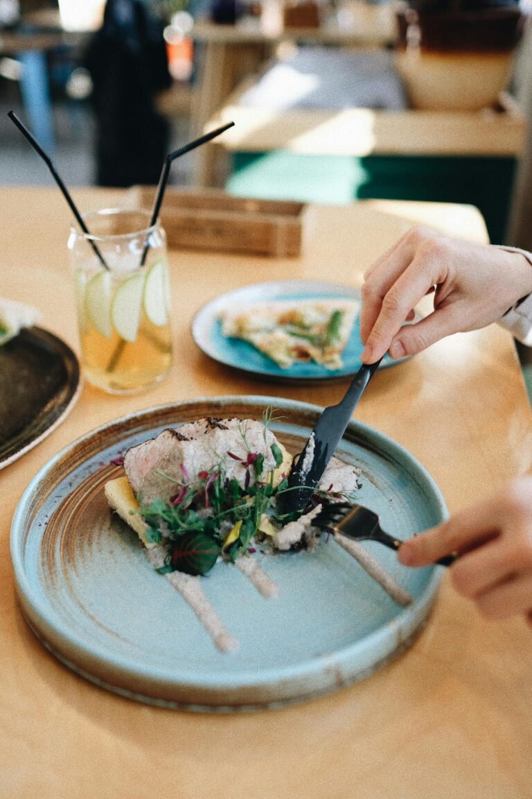 Crop anonymous person eating original salad cooked by molecular gastronomy technology in modern restaurant